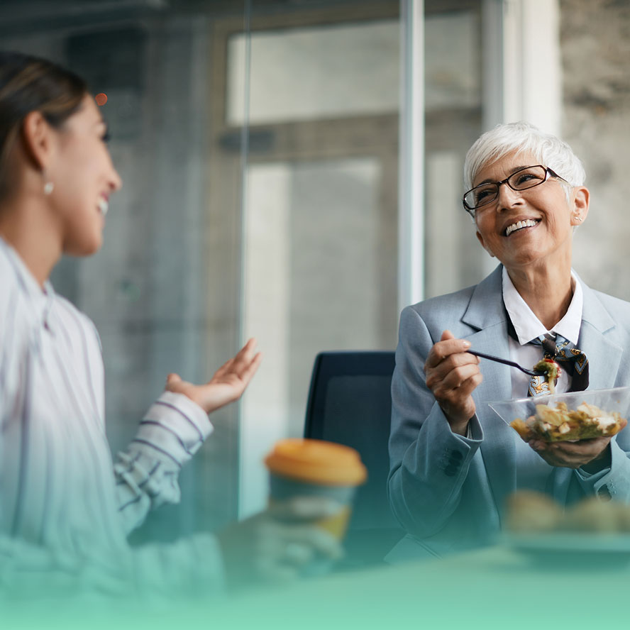 Two smiling women eating lunch